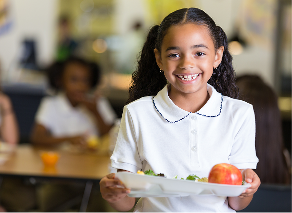 Elementary School Elementary school student holding her lunch tray.