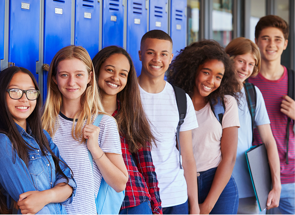 Middle School Middle school students posing for a photo by their lockers