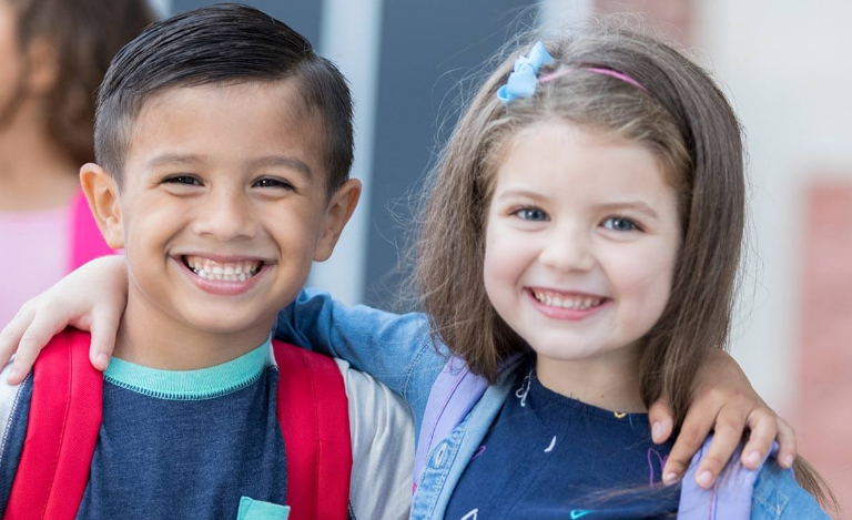 kids smiling with arms around each other