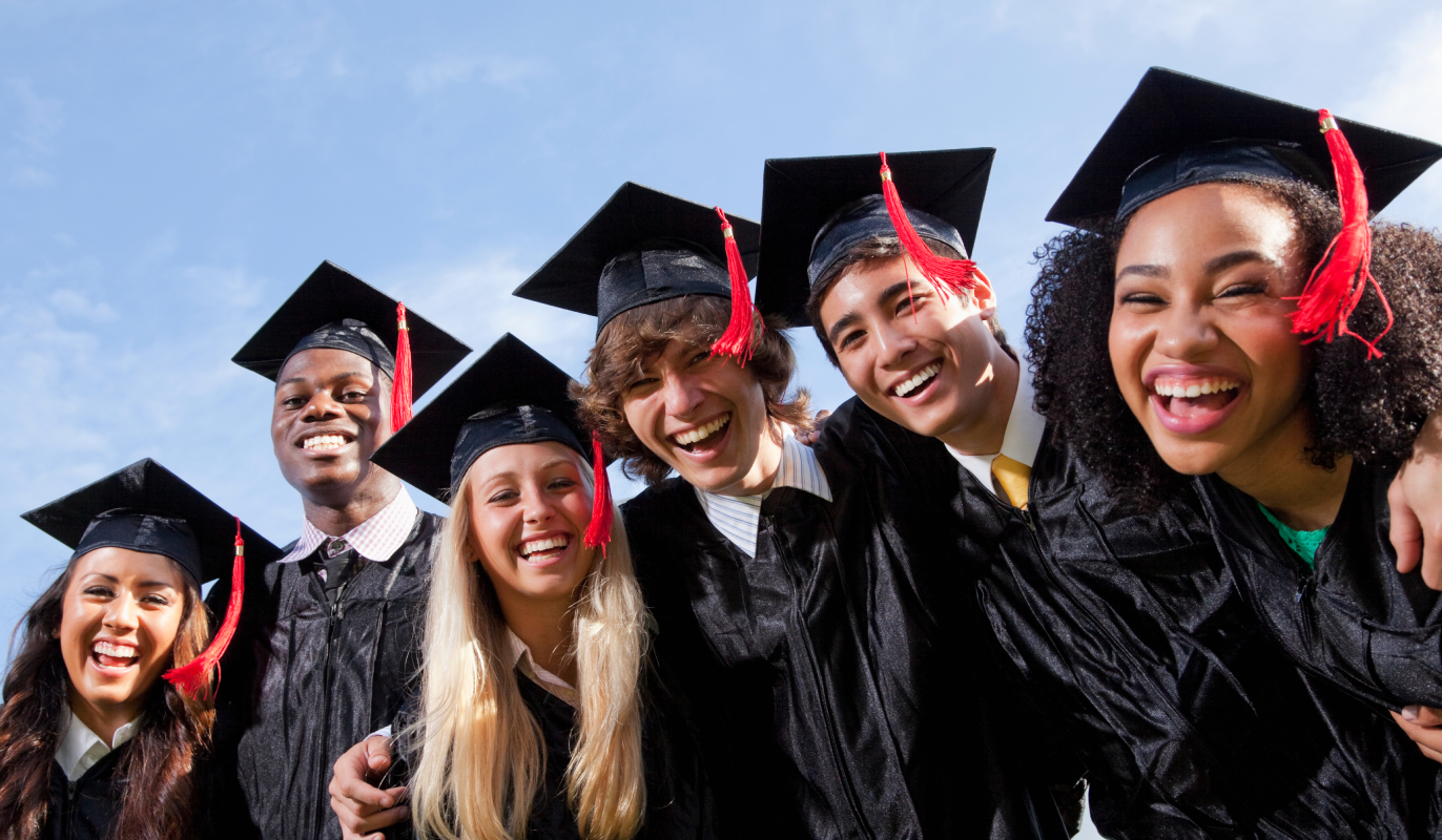 High school graduates standing together in cap and gown.