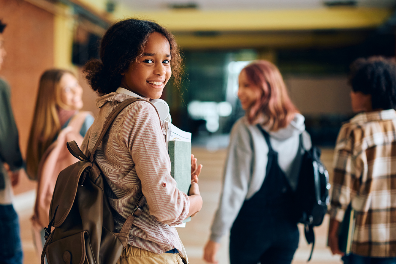 Students carrying books in a hallway