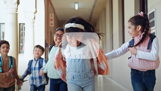 Image of kids running in a corridor together, with a play button overlay.